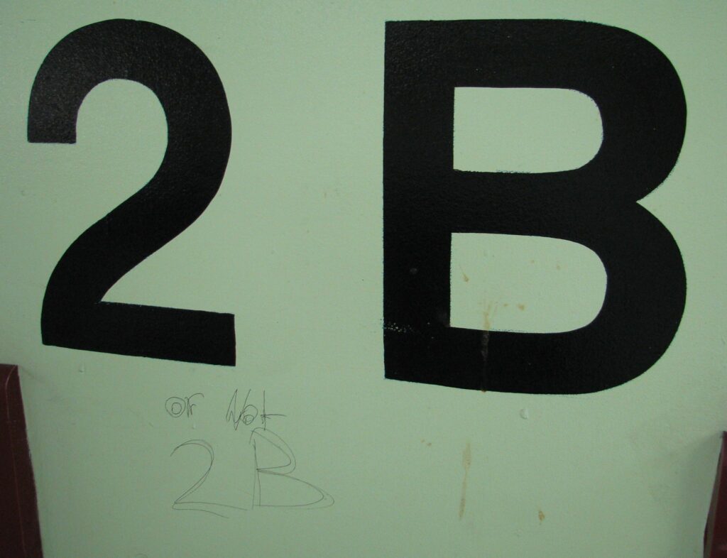 A carpark sign showing row 2B that someone has scrawled underneath "Or not 2B!"